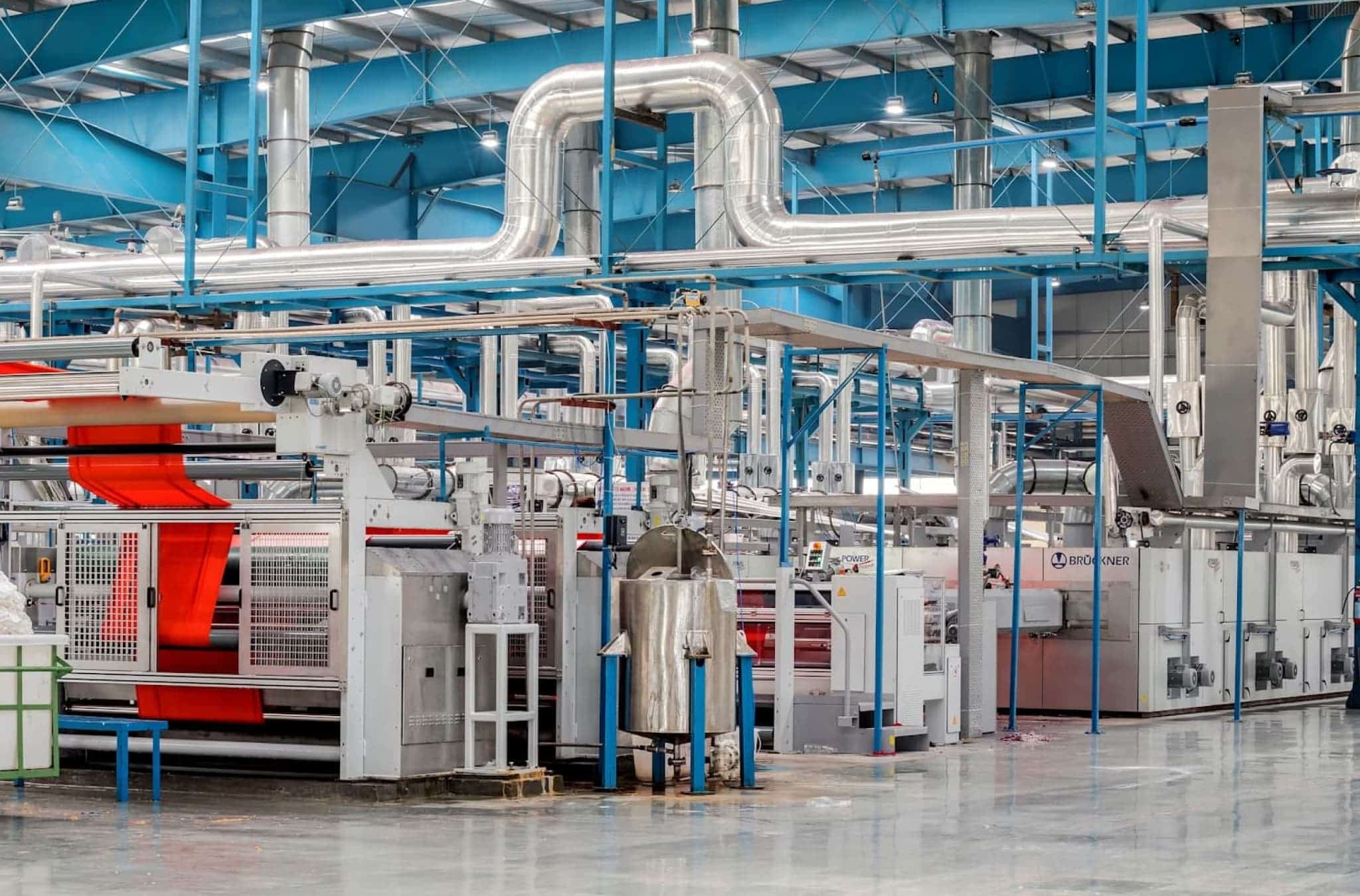 Σύγχρονη βιομηχανική μονάδα παραγωγής με αυτοματοποιημένα μηχανήματα και γραμμή επεξεργασίας υφάσματος σε εργοστάσιο